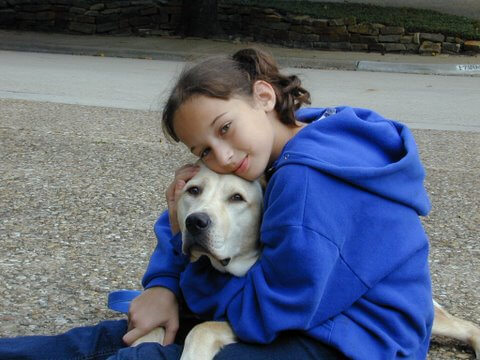 Girl snuggling with dog